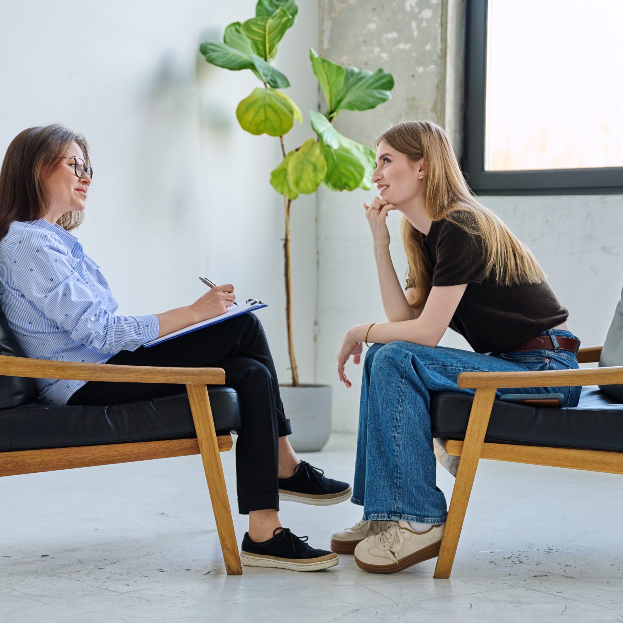 Two women engaged in a serious conversation in a cozy room.